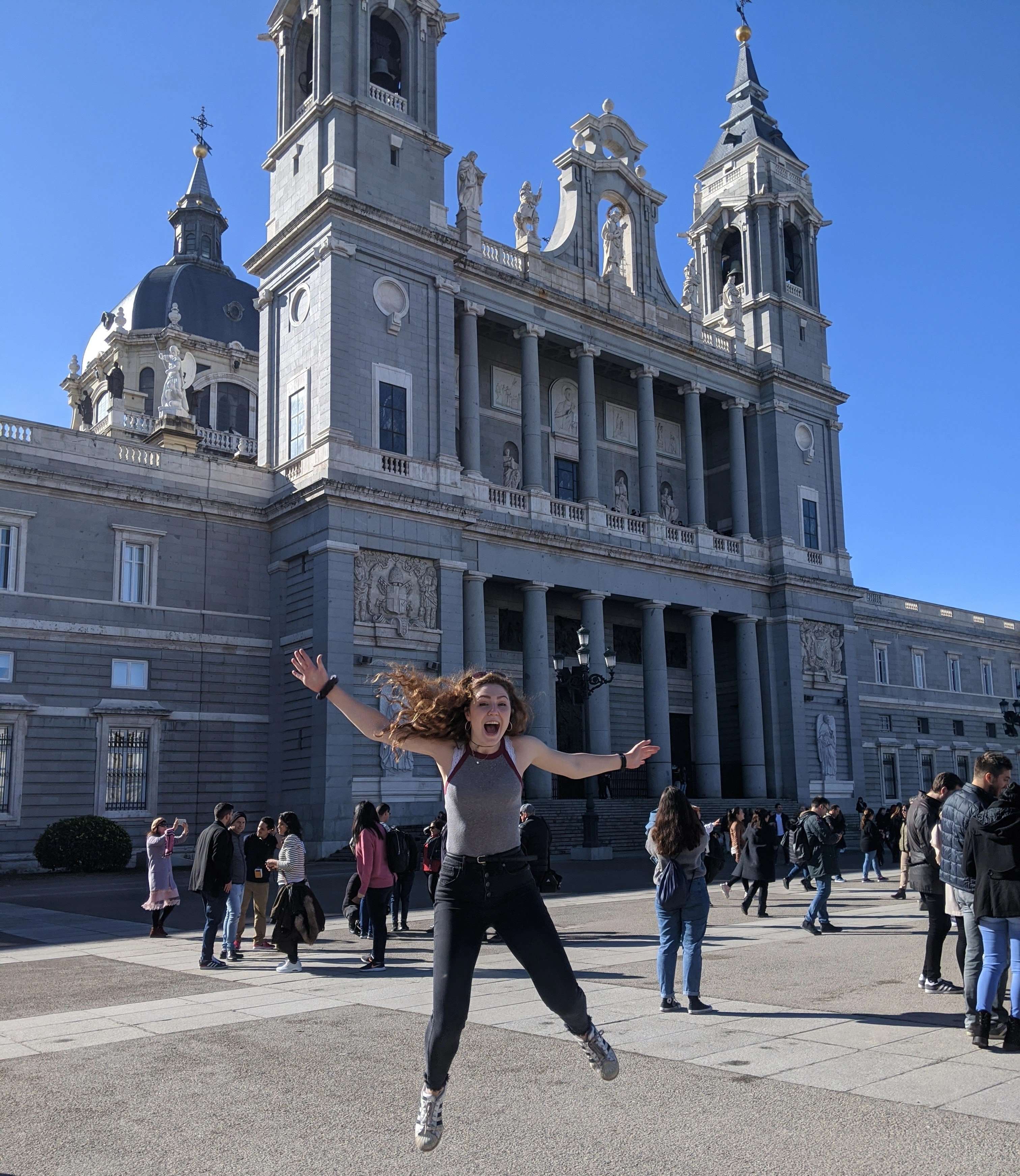 Liz jumping in front of the Almudena Cathedral in Madrid, Spain
