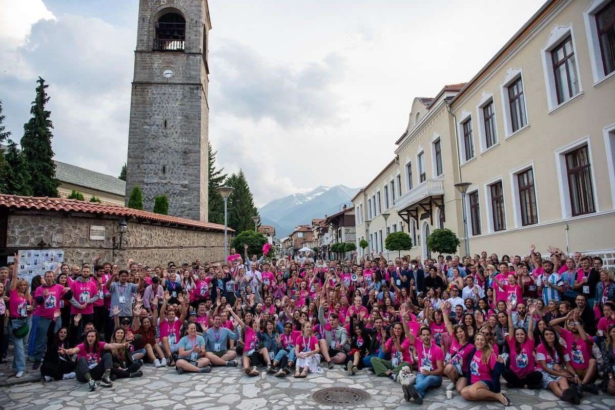 Everyone participating in the festival taking a picture together with the mountains in the background