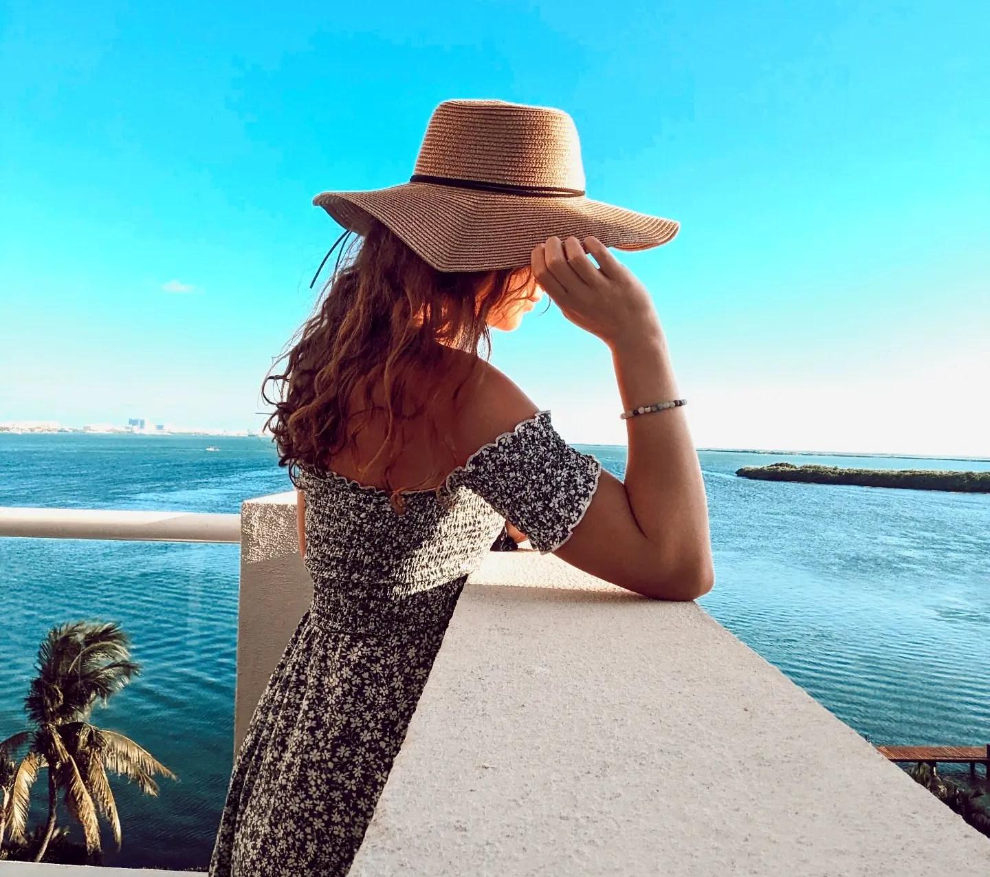 Posing with sunhat, looking at the ocean in Cancun Mexico