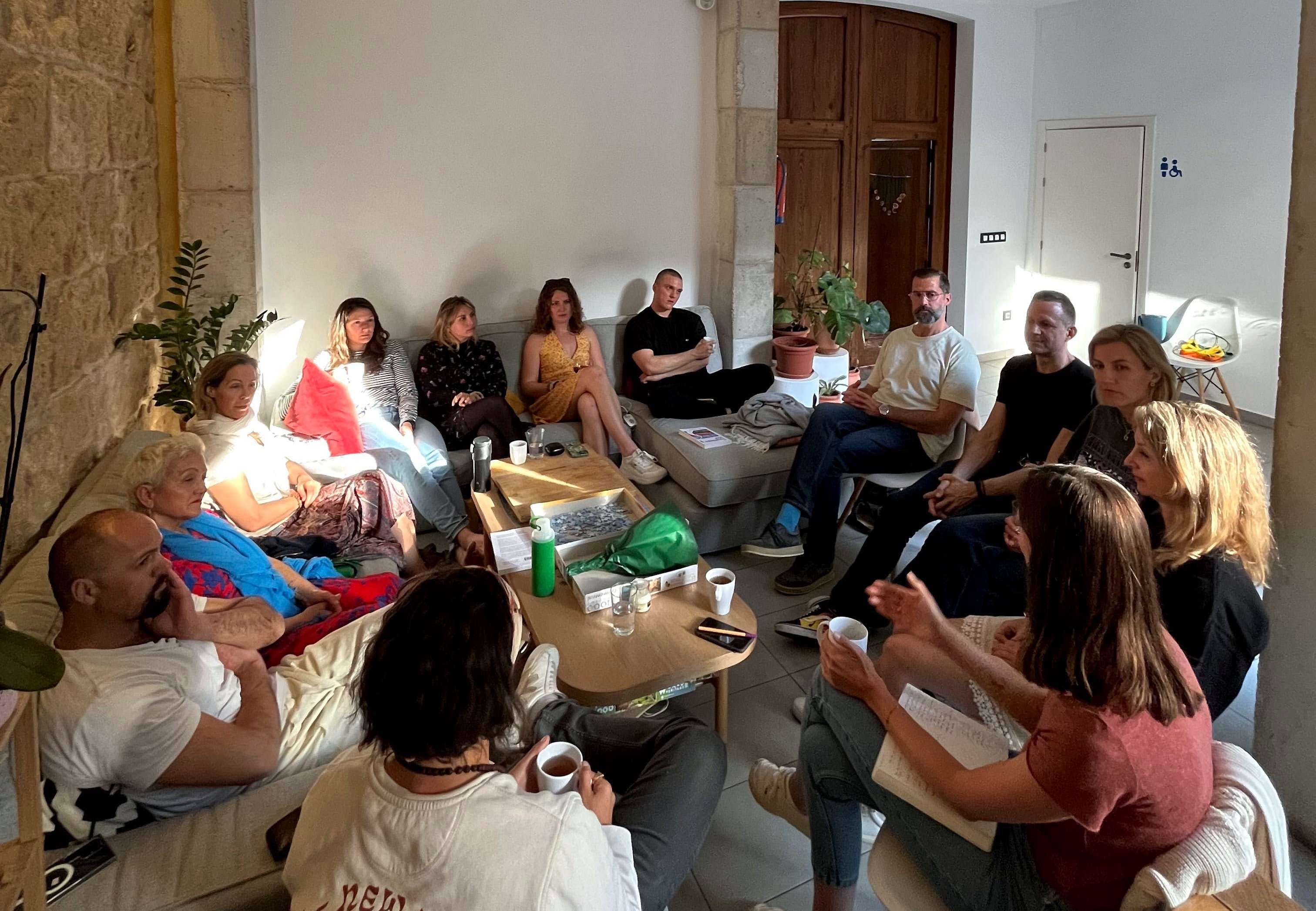A group of people sitting in a circle at Sun & Co discussing a topic.