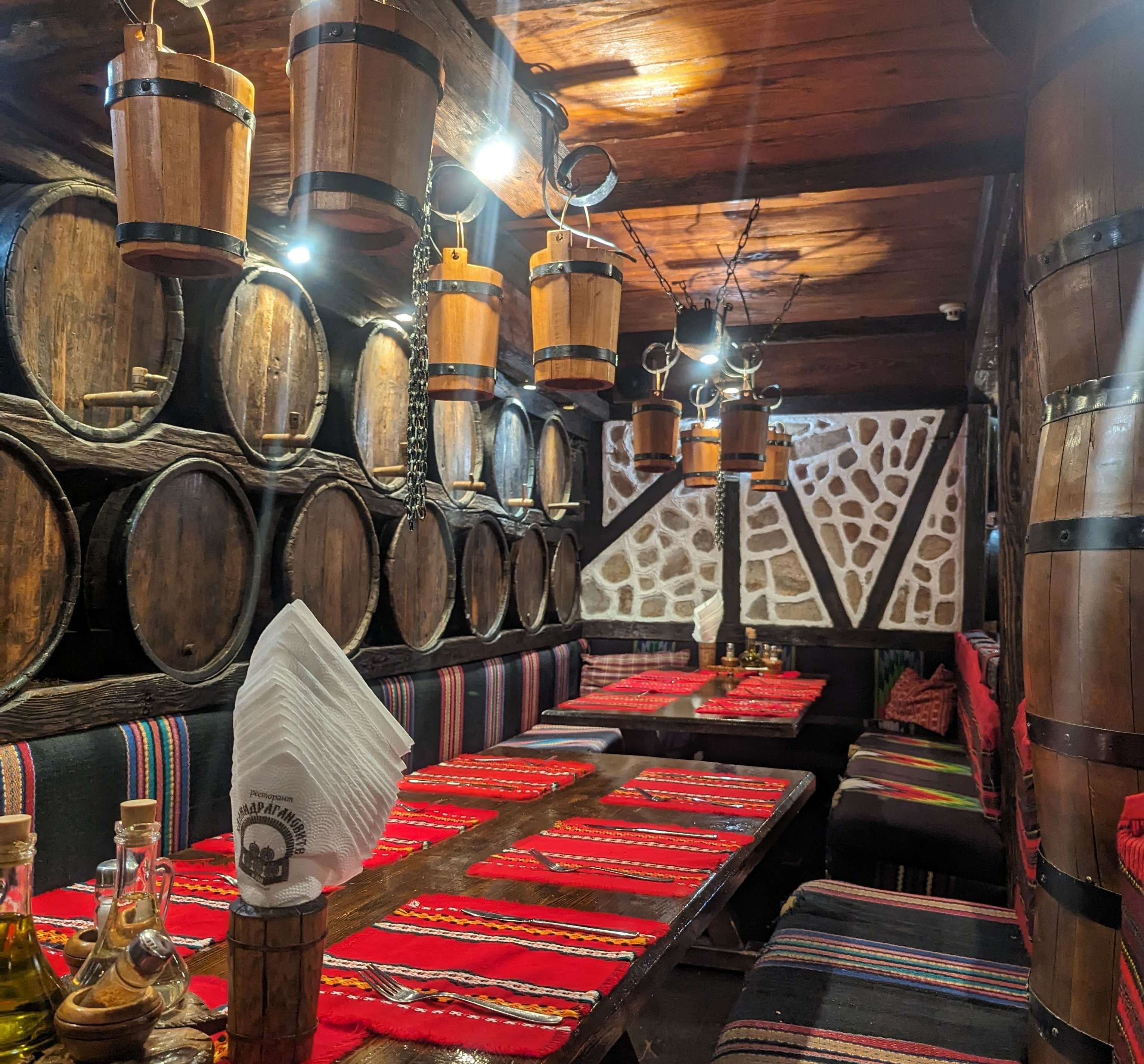 Traditional Bulgarian Restaurant with Wooden Barrels and red placemat.