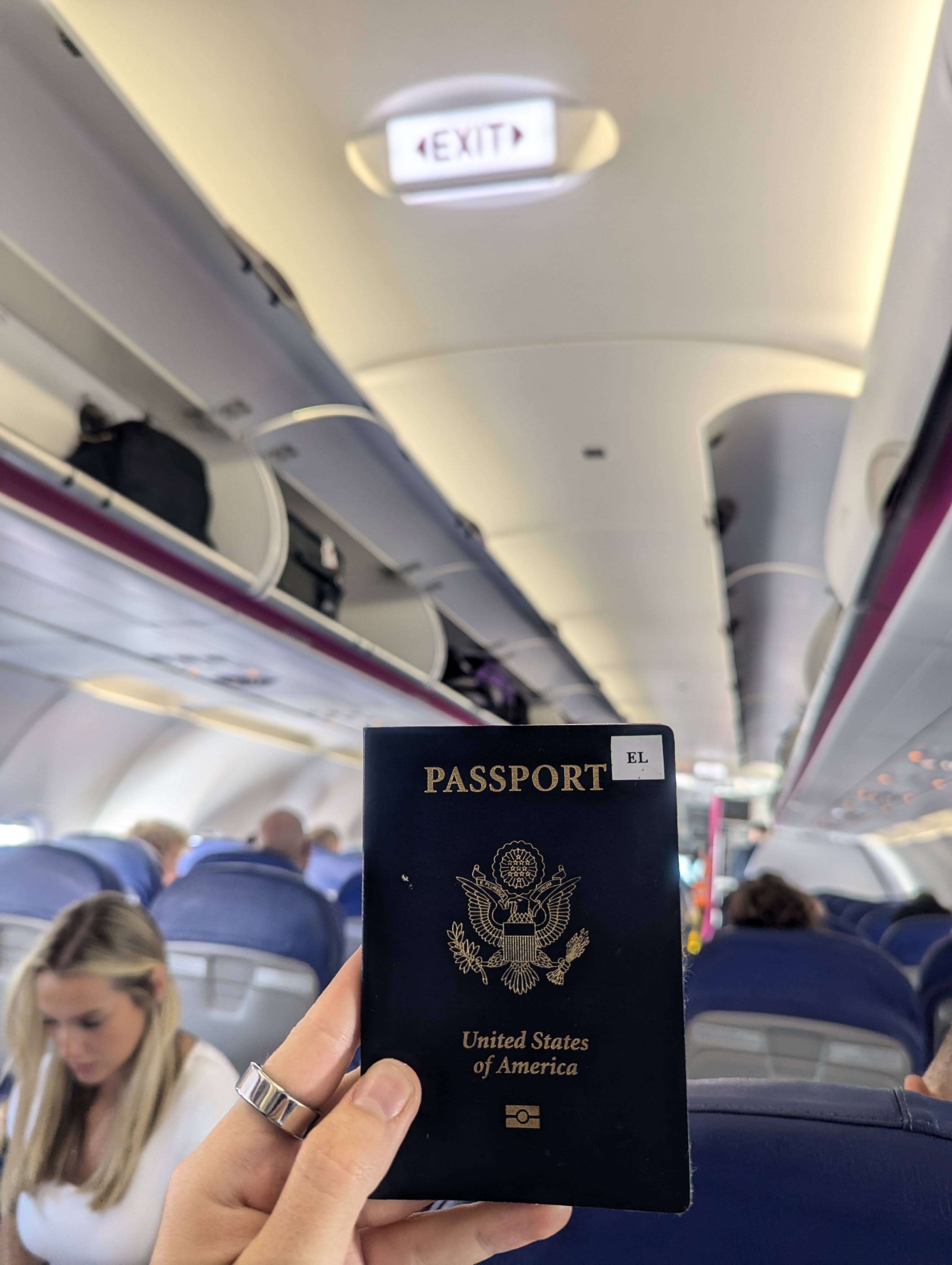 A picture of the front of my passport on an airplane.