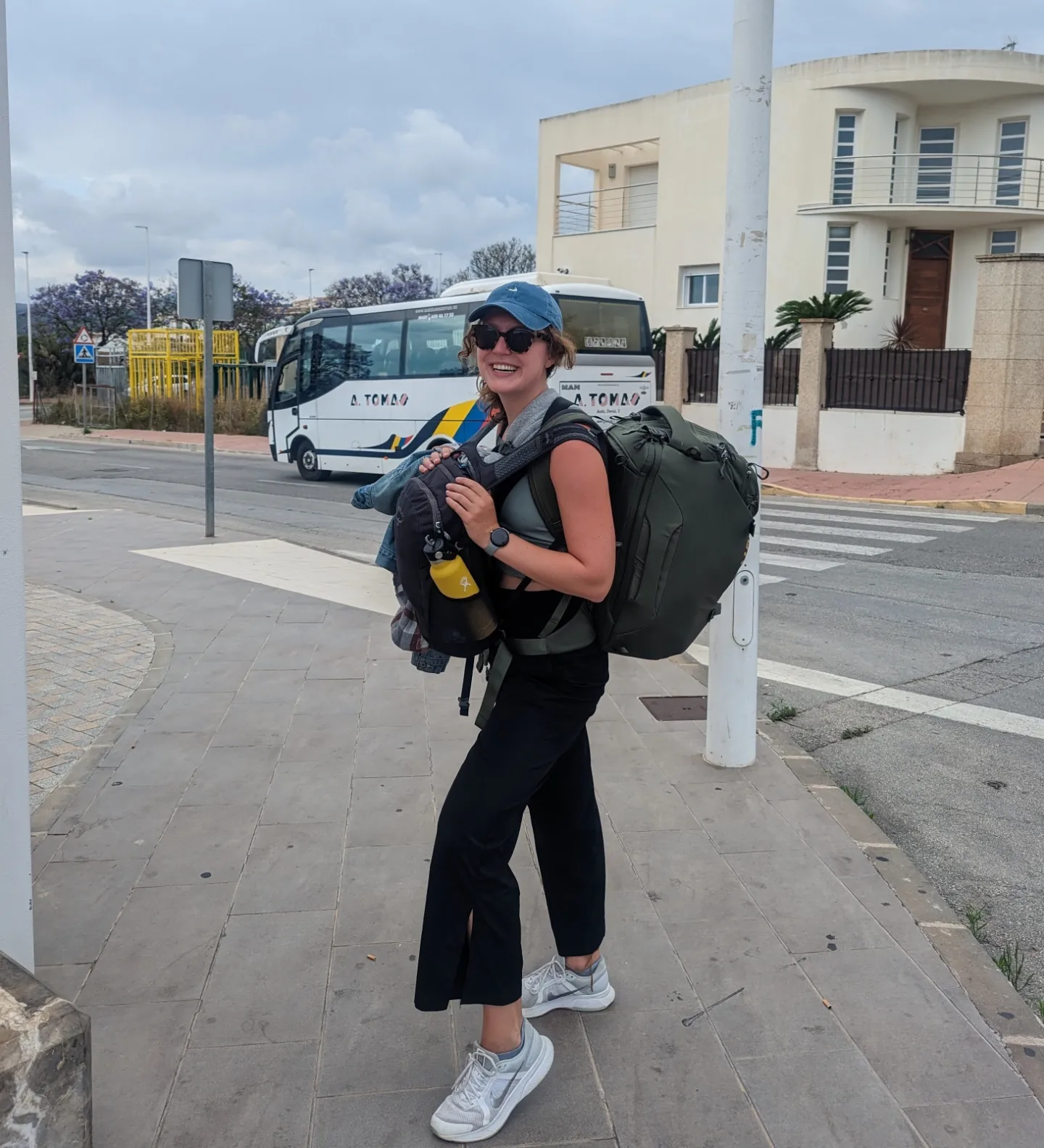 Me (Traveler Liz) posing with my massive travel backpack and my smaller backpack in front.