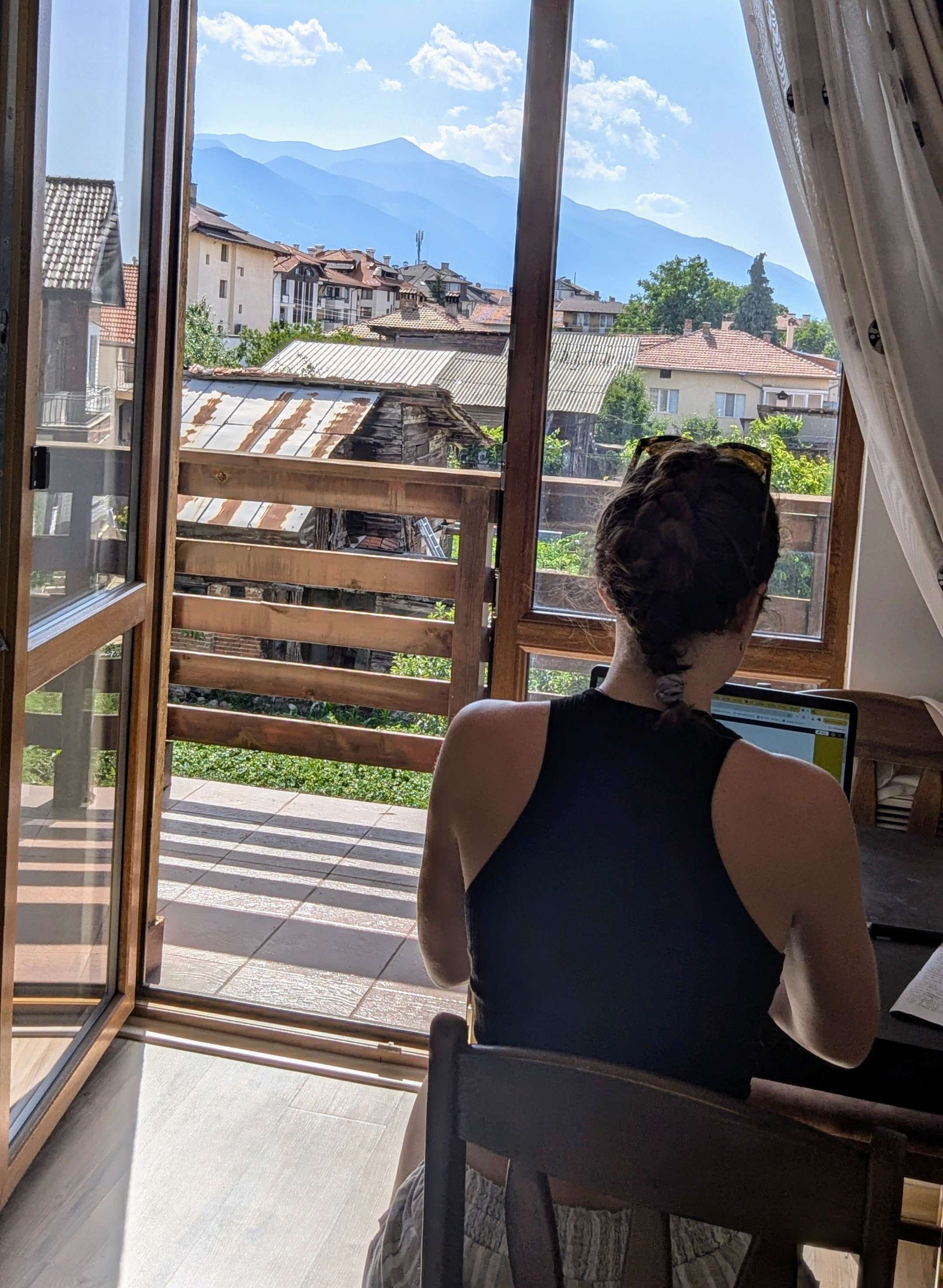 Me (Traveler Liz) facing towards the Bulgarian mountains while researching on my laptop.