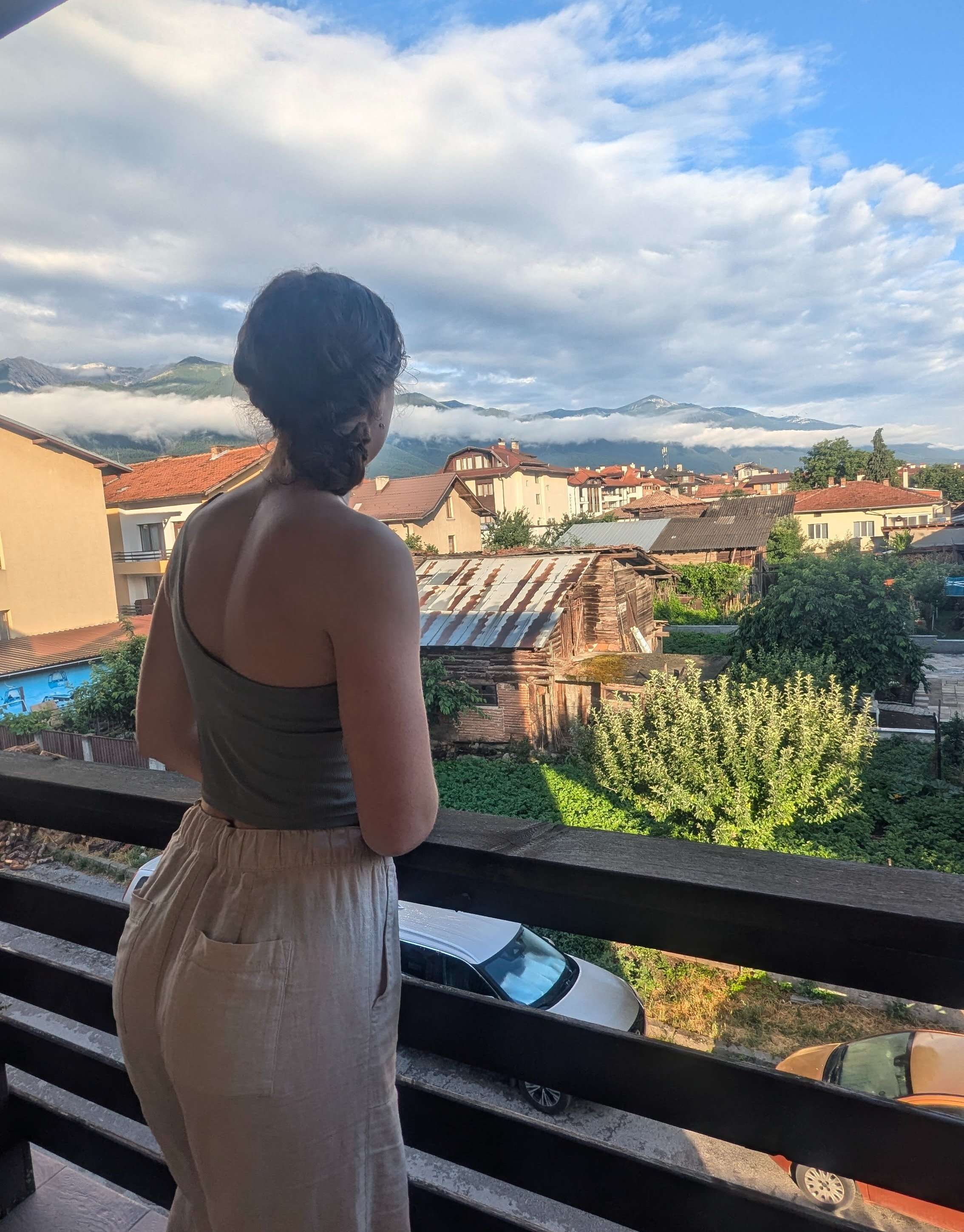 Me (Budget Traveler Liz) staring off into the distance at the mountaintops in Bulgaria from my accommodation's balcony.