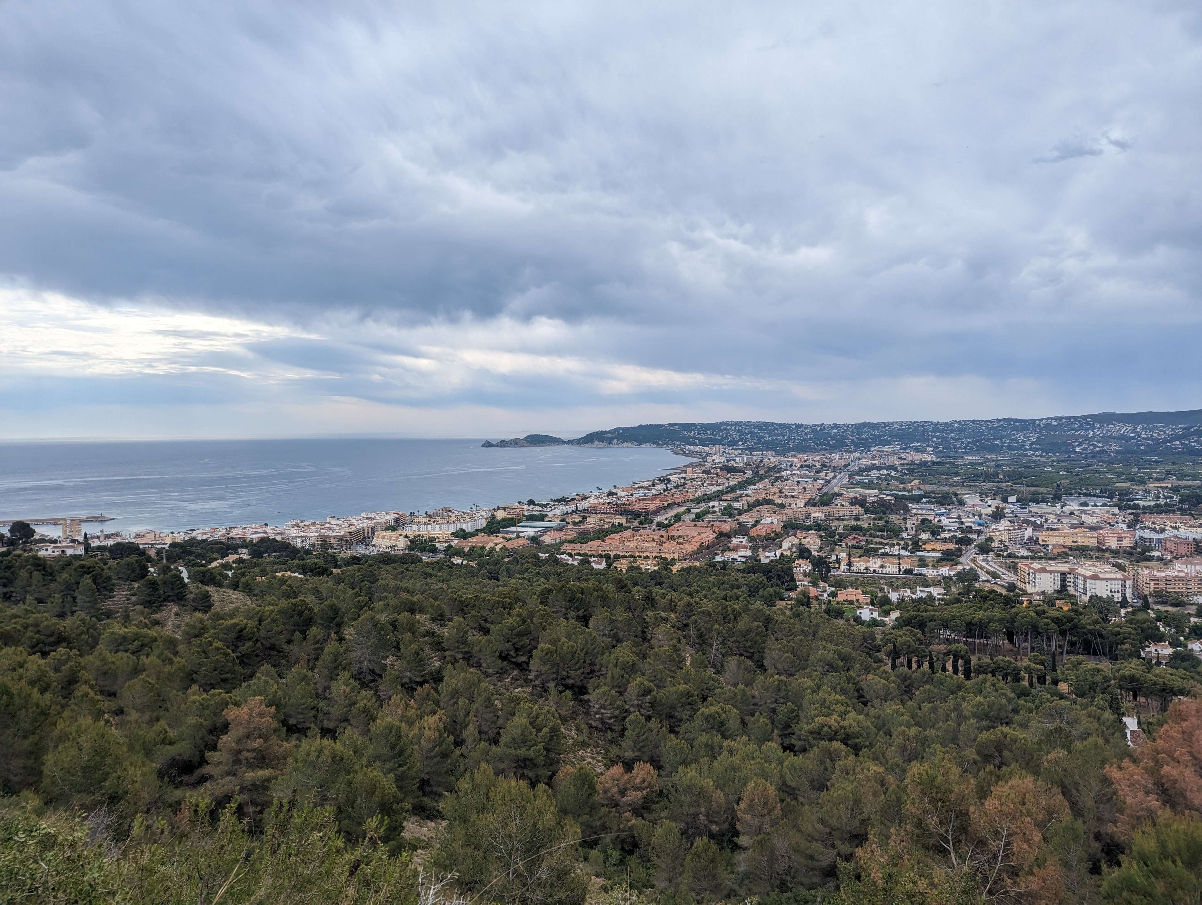 A view of the city from the windmills in town overlooking the ocean and all the houses.