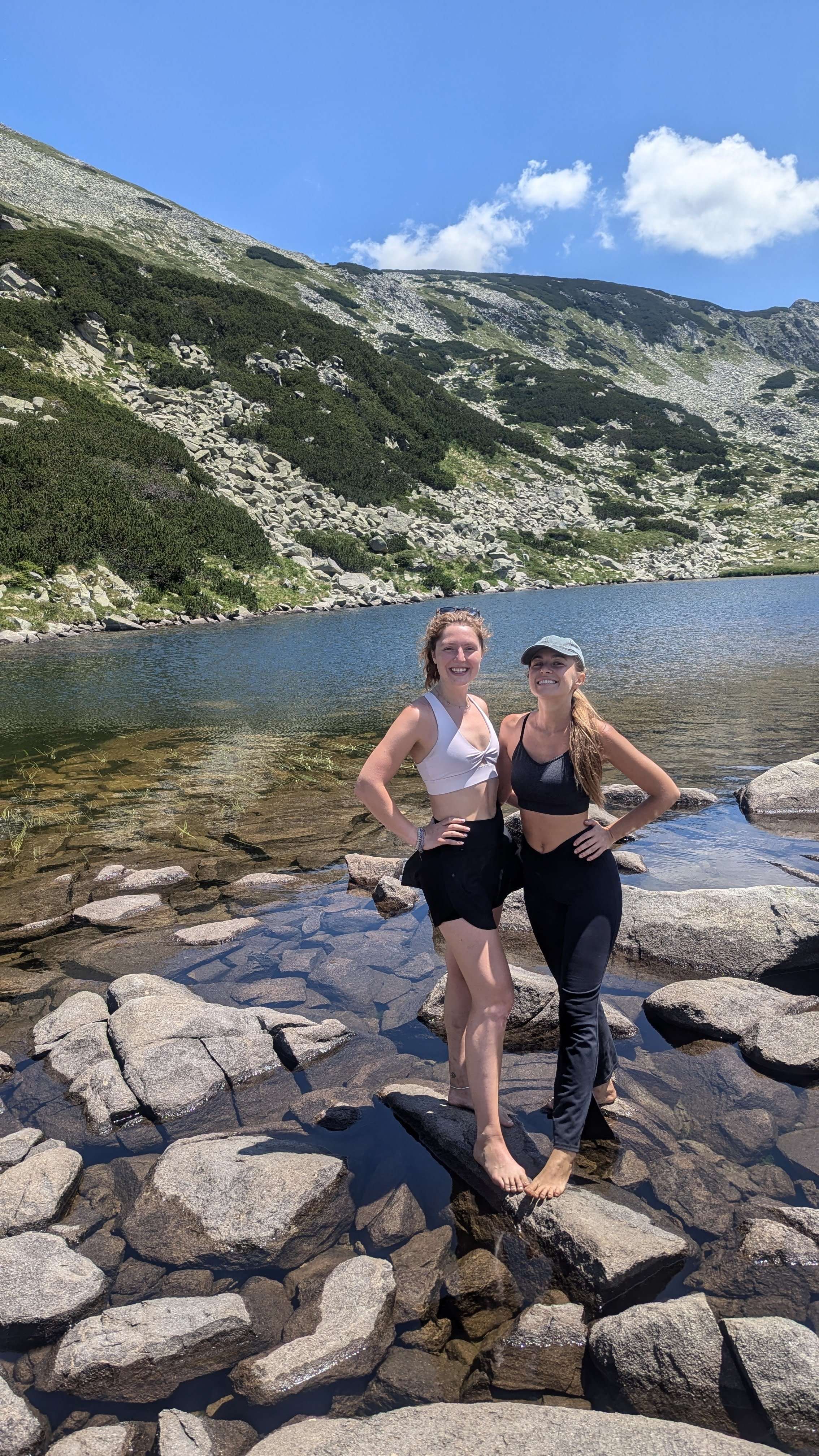 My friend and me (Traveler Liz) standing on rocks in our bare feet while hiking.