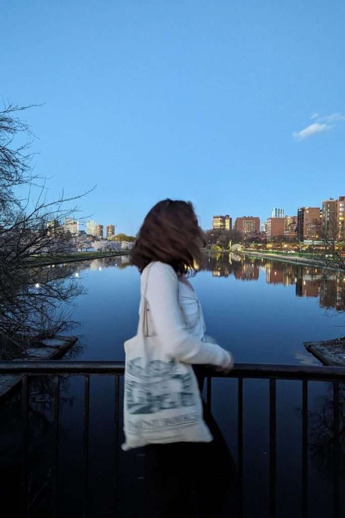 Liz walking along the esplanade in the spring looking at the buildings.