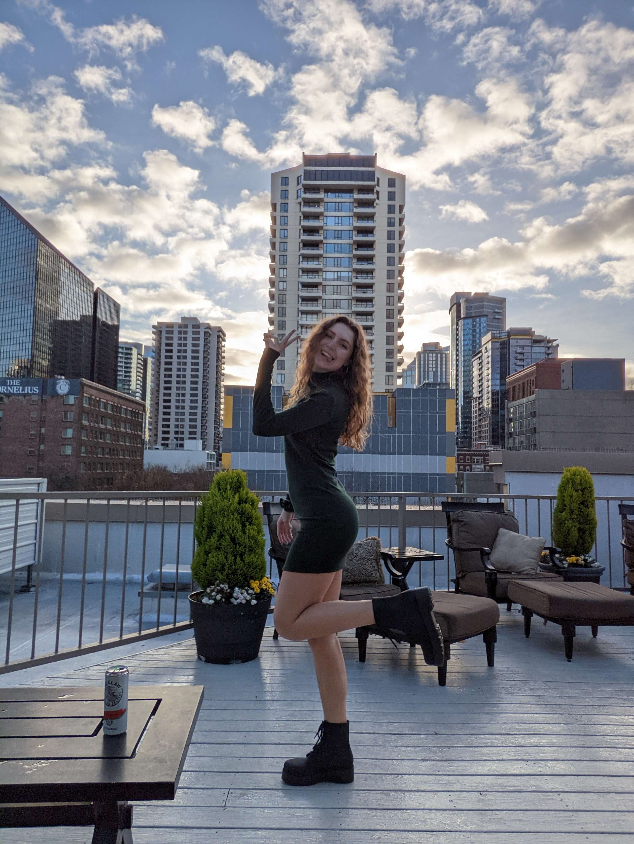 Me (Traveler Liz) standing on the rooftop at the Belltown Inn with the buildings behind me.