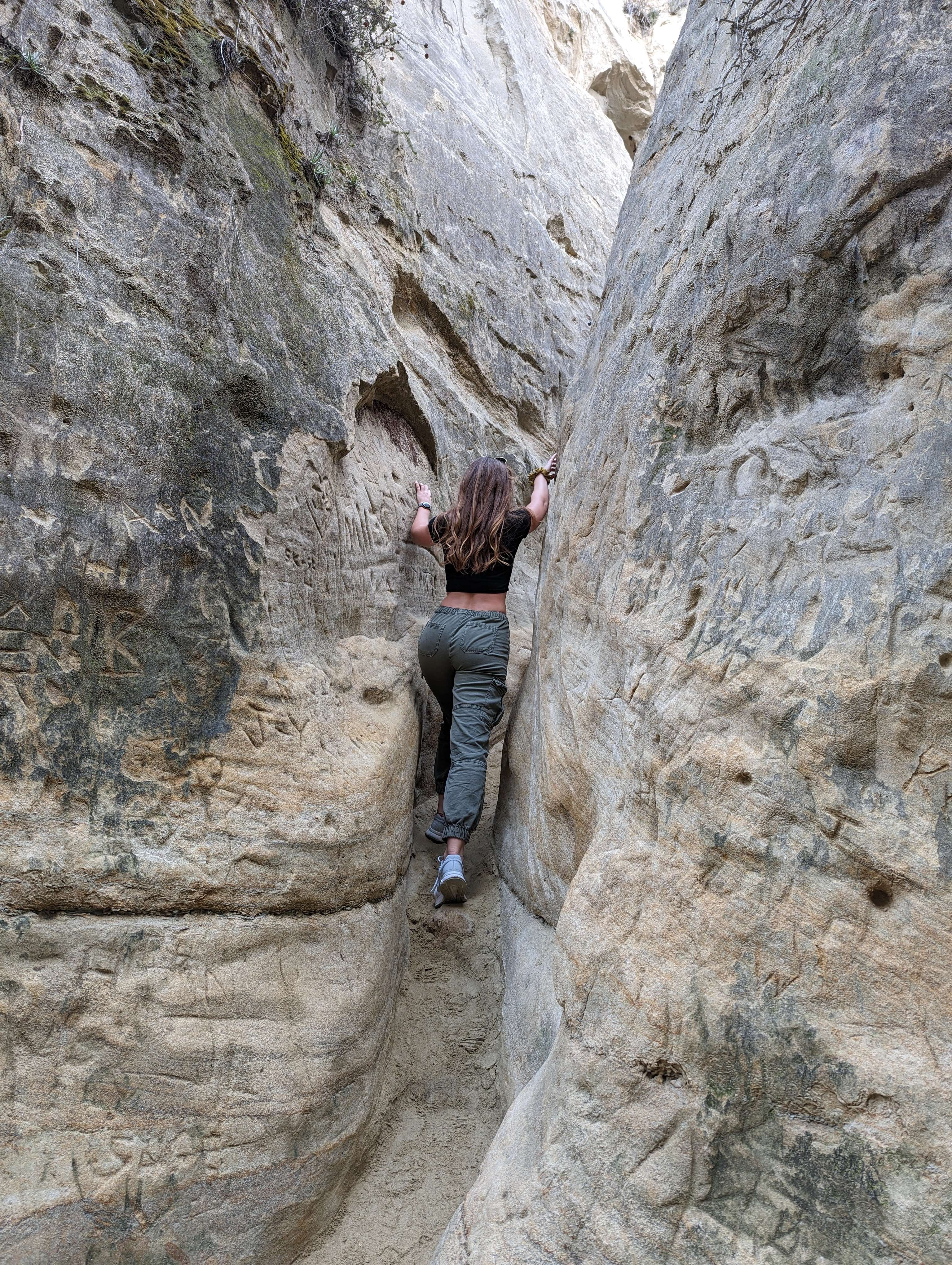 Traveler Liz climbing through a canyon on Annie's Canyon trail.