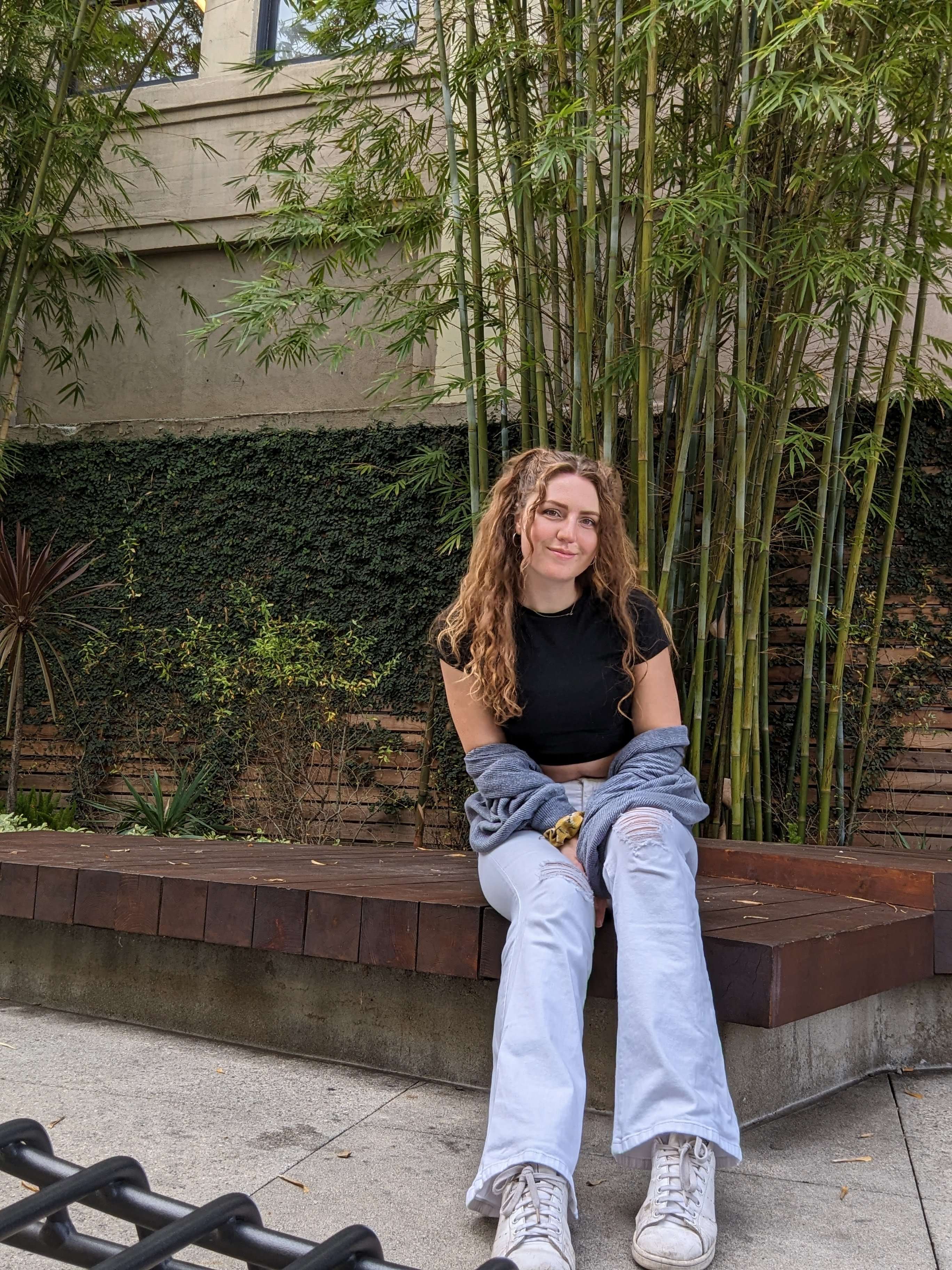 Traveler Liz sitting on a bench in front of bamboo in LA