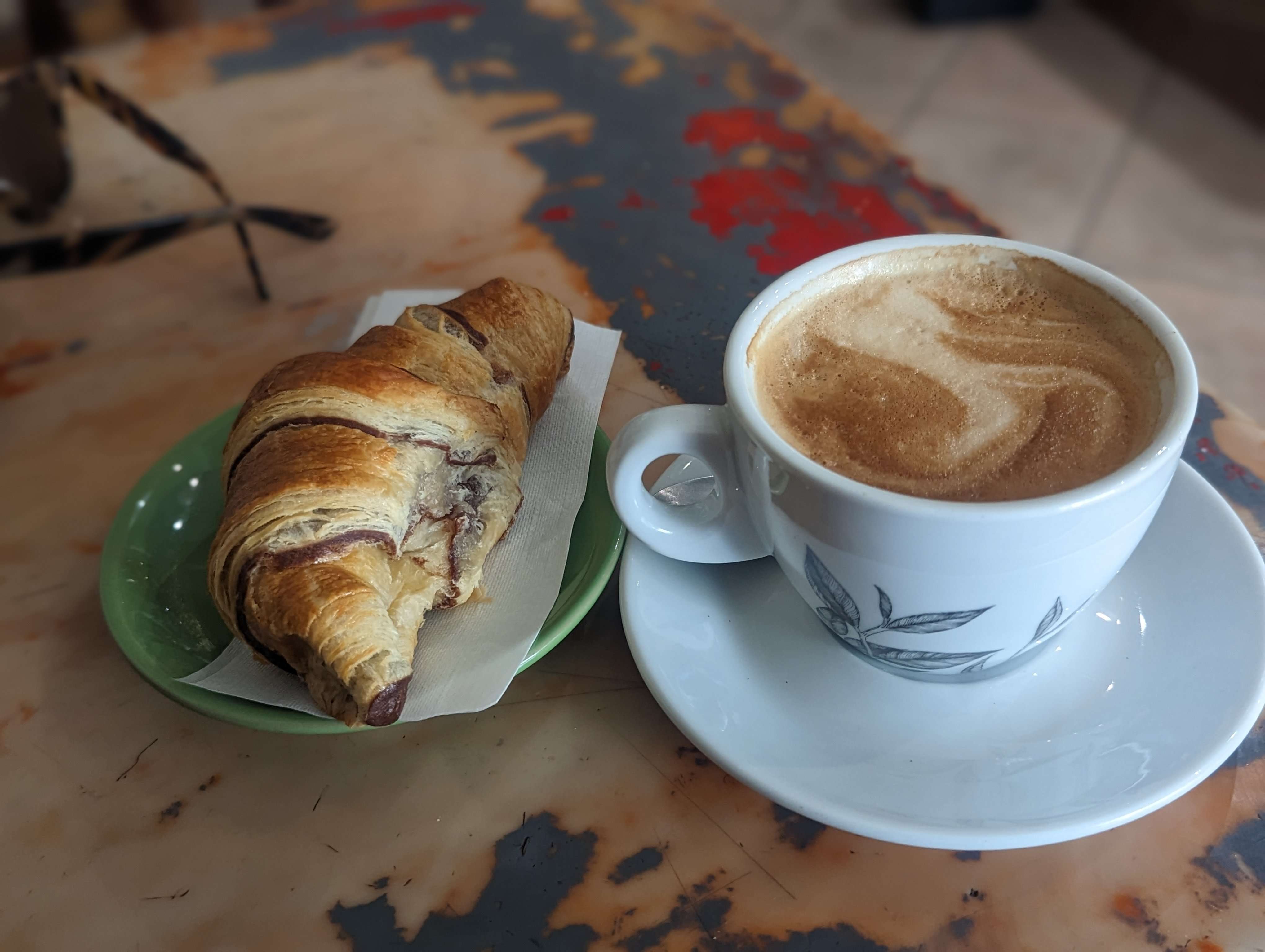 A chocolate croissant and cappuccino at a cafe in Florence.