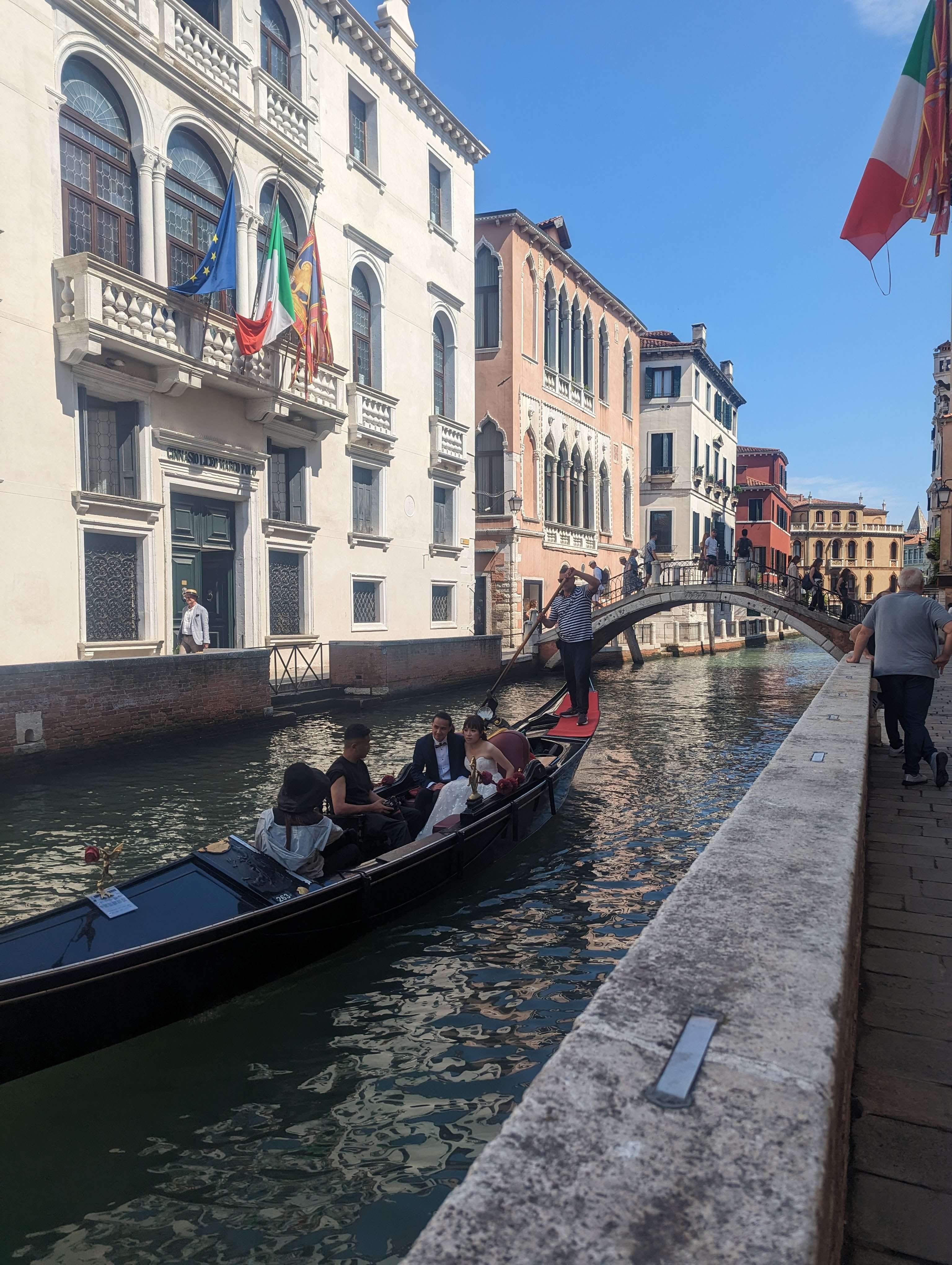 A gondola floating down a canal in Venice, with beautiful buildings behind it.