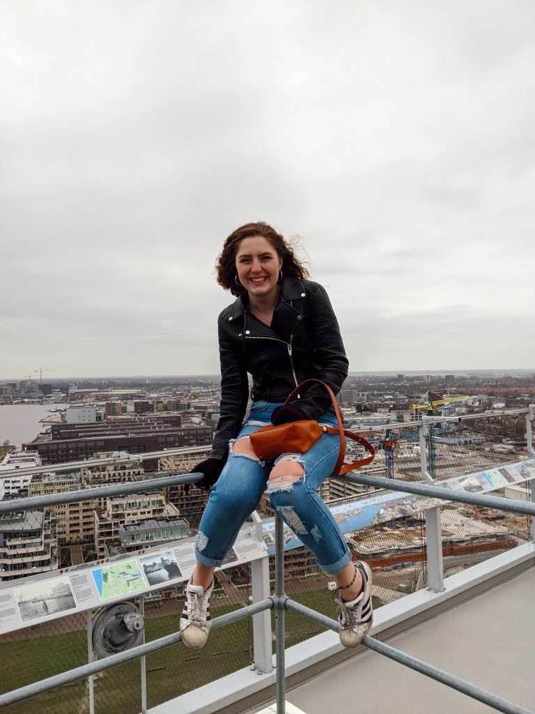 Traveler Liz sitting outside the A'dam Lookout on the roof
