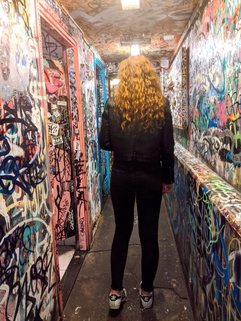Traveler Liz inside Cafe Hill Street Blues surrounded by graffiti in Amsterdam