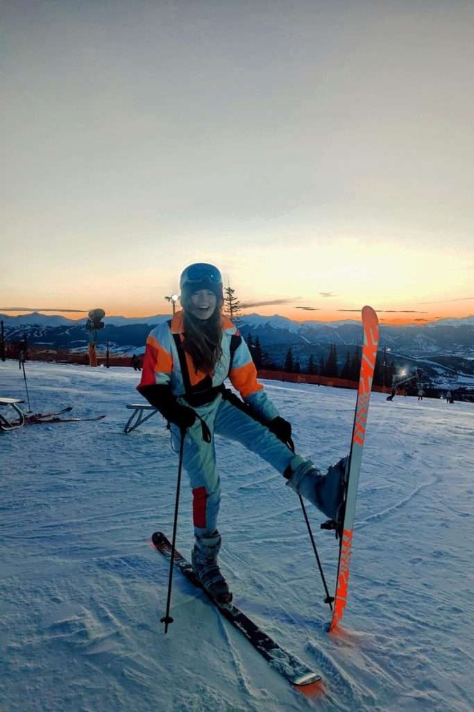 Skier Liz laughing at sunset on the slopes in Keystone, Colorado, with mountain views in the background.