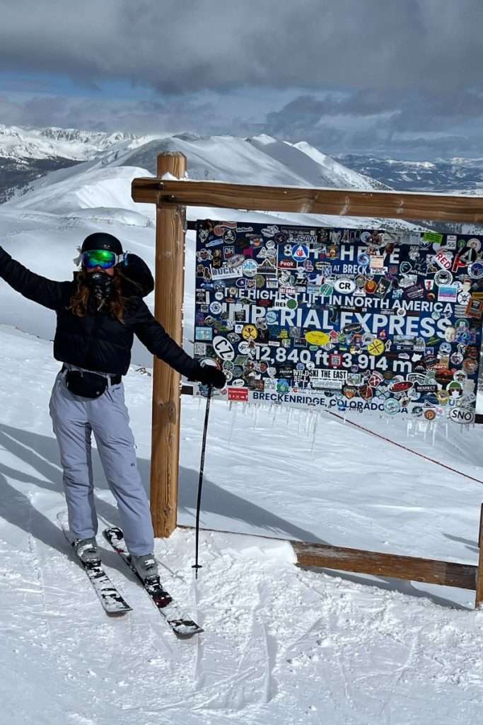 Skier posing at high altitude at the top of the Imperial Express lift at Breckenridge, Colorado, the highest chairlift in North America at 12,840 feet.