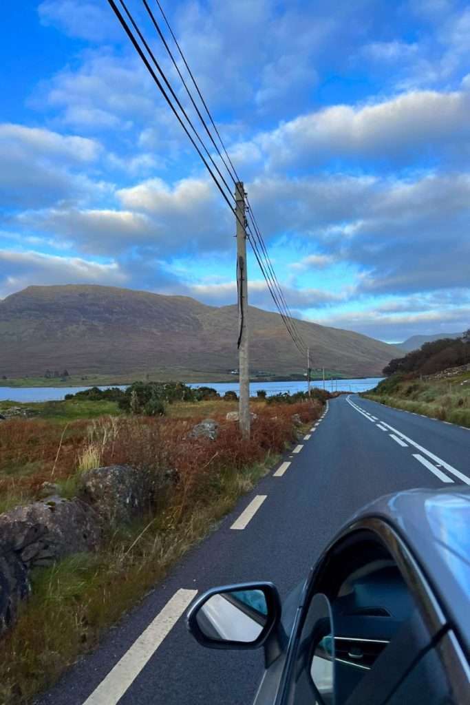 Beautiful view driving on a road in Ireland leading to a lake