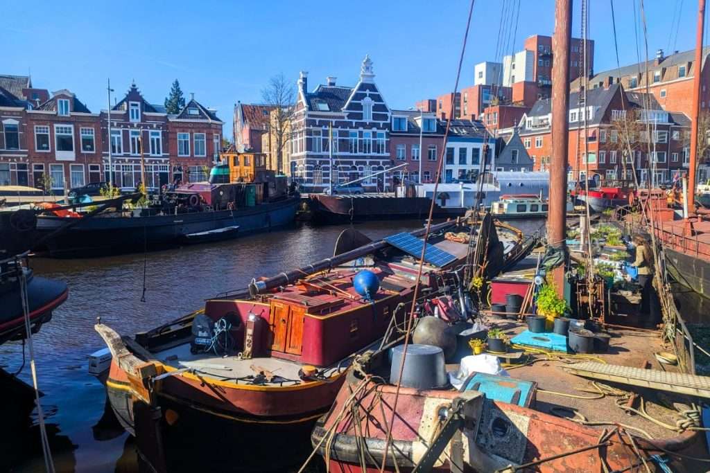 Boats in the canal in Groningen surrounded by the Dutch style houses