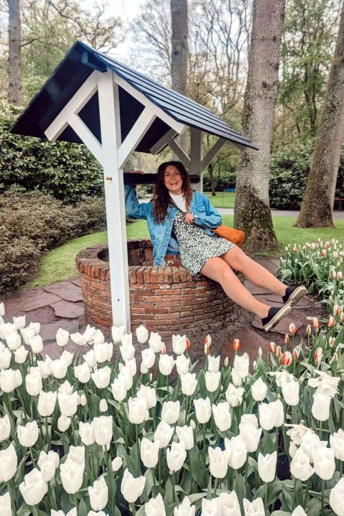 Liz sitting in a well in Keukenhof gardens in the Netherlands