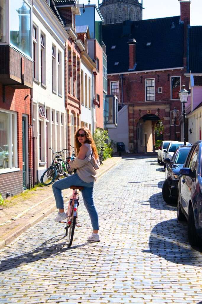 Liz standing on the street while on a bike in Groningen
