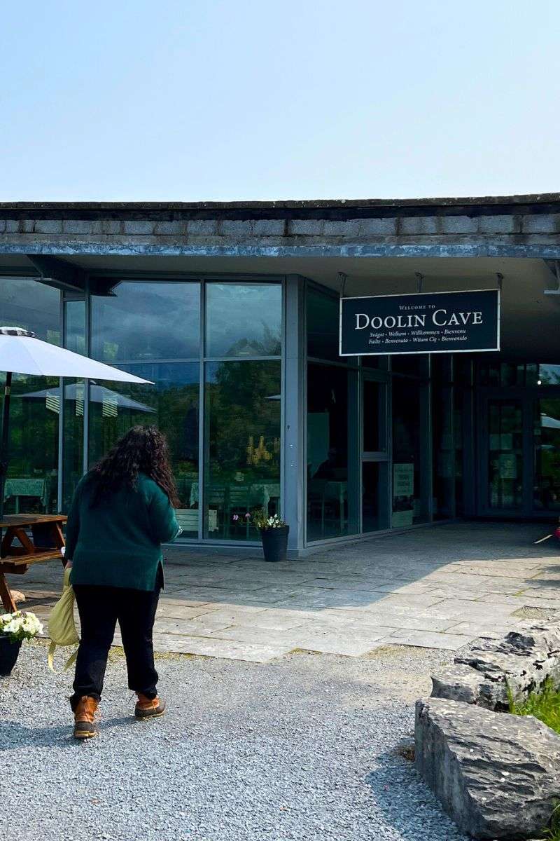Woman walking toward the entrance of Doolin Cave in Ireland during a day trip from Galway