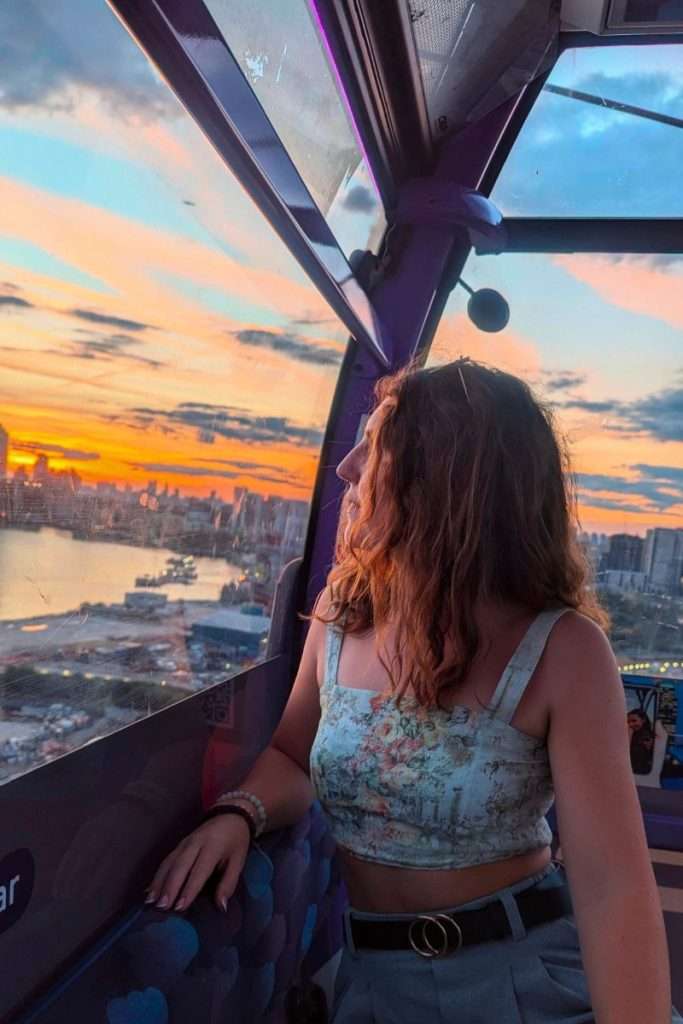 Traveler Liz staring out the window of the cable car from the Royal Docks headed west.