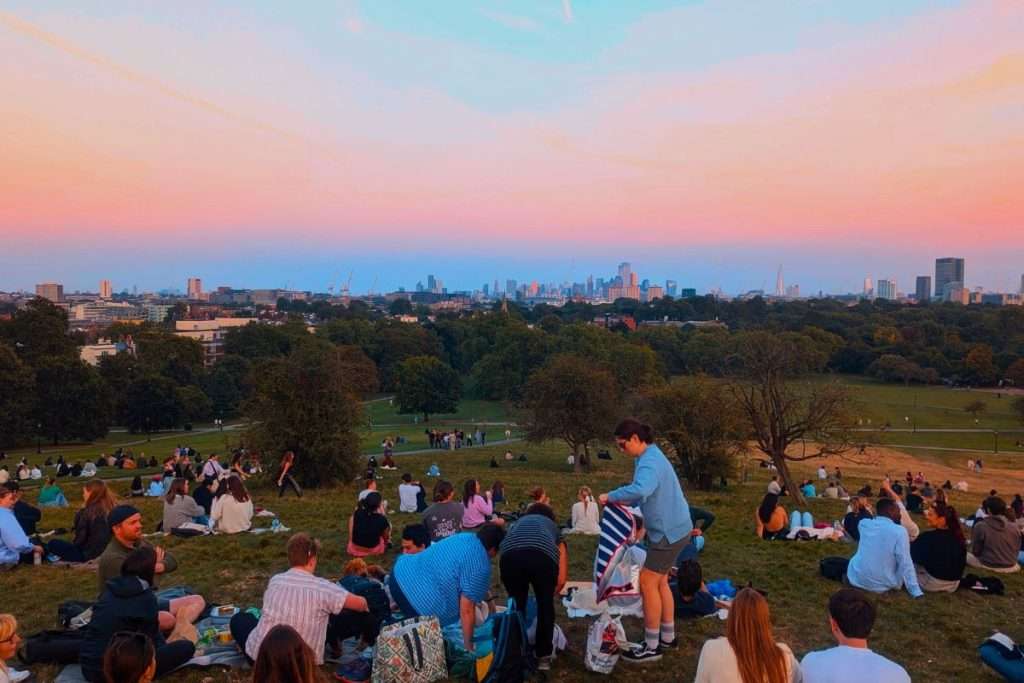 Primrose Hill sunset outside the East of London with lots of people picnicking.