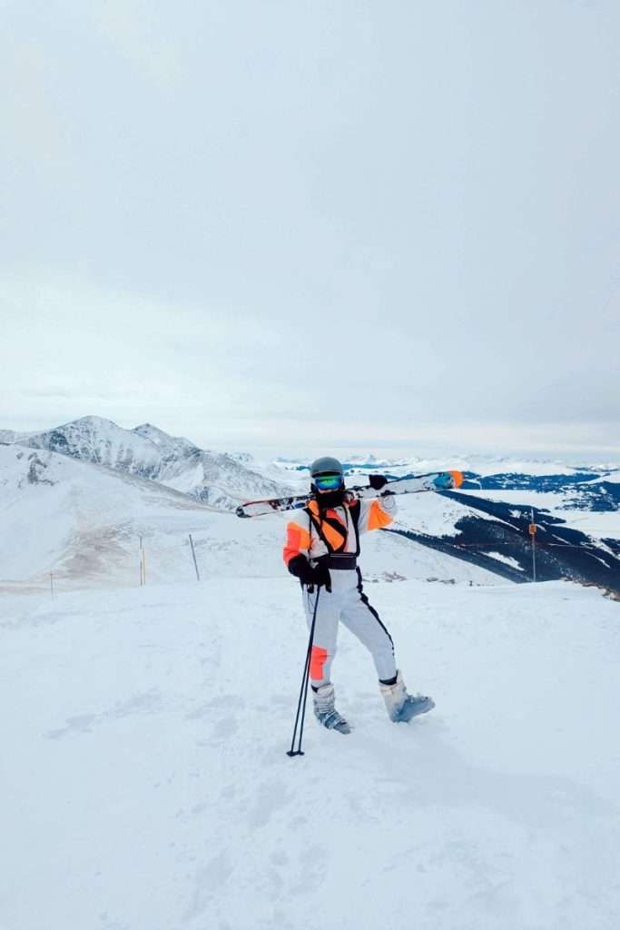 Liz holding skis on a white out day on top of the tallest mountain in Breckenridge Ski Resort.