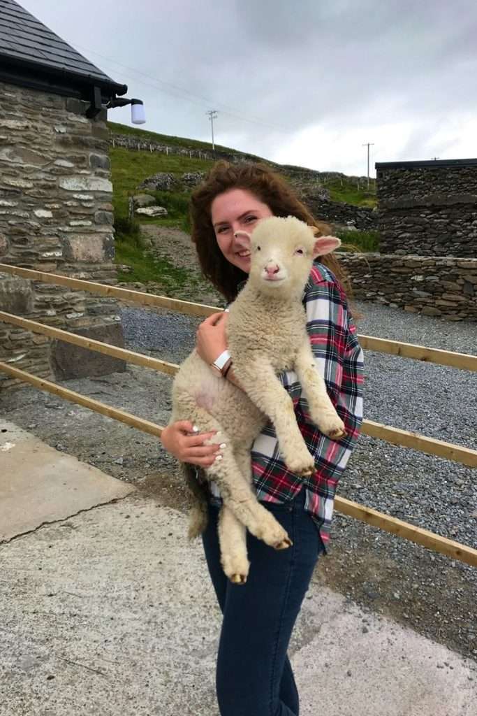Liz holding a lamb on the Slea Head Drive route.